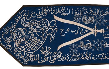 A blue cloth shaped in the form of an arrow, with Arabic calligraphy and the sword of Ali open on two sides inside of it