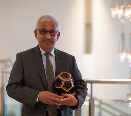 Professor Karim H Karim holding the sculpture awarded to him.
