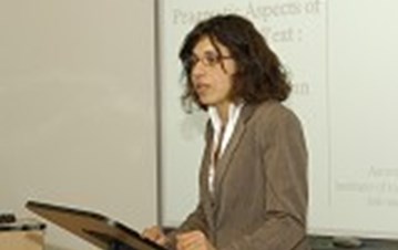 A lady in grey suit presenting at a podium