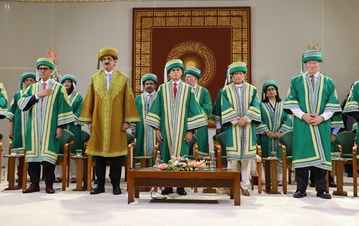Princess Zahra, IIS Board of Governors, faculties and students all standing in respect in two rows wearing AKU graduation gowns
