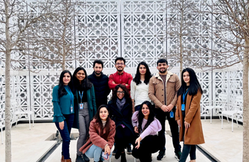 STEP C14 students standing in a group with Farah Manji (IIS faculty) in the centre posing for a picture in the terrace of Aga Khan Centre (AKC)