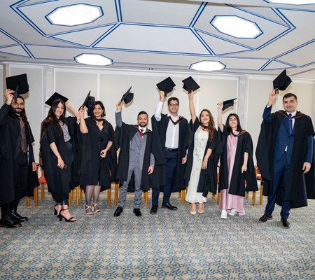 GPISH 2023 graduates wearing graduation gowns and throwing caps in the air