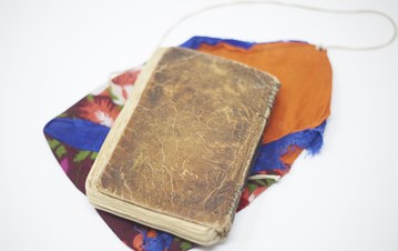 A book from the IIS archive placed over a colourful piece of cloth