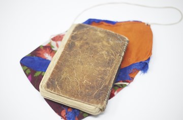 A book from the IIS archive placed over a colourful piece of cloth