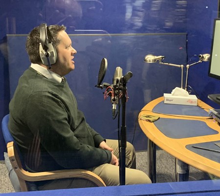 A side view of Dr Stephen Burge, reporting an audiobook on Prophet Muhammad from the recording studio