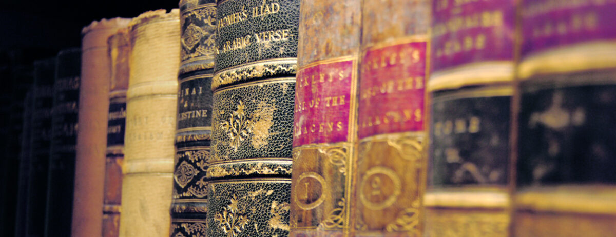 Nine colourful books arranged in an order (side view)