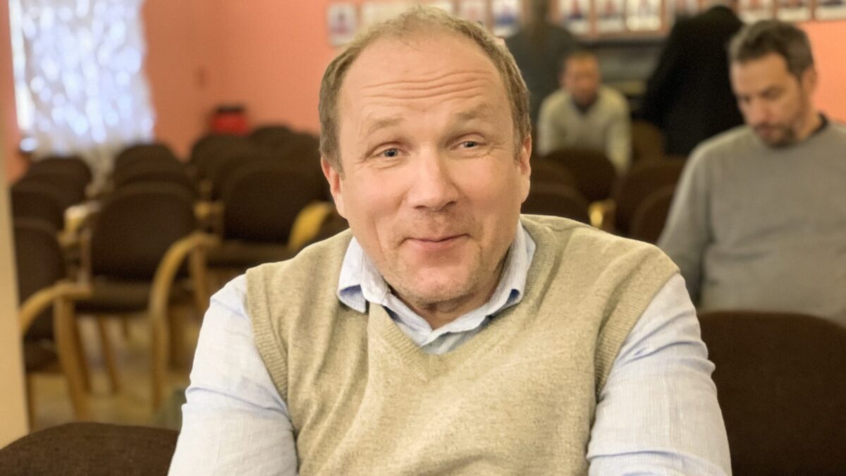 Dr Janis Esots, an esteemed scholar in white shirt and light yellow sweater