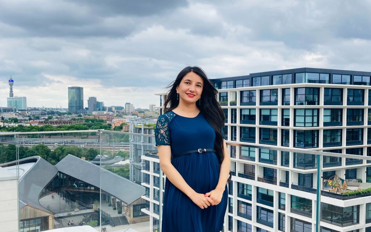 GPISH student dressed in dark blue dress standing on the right corner of terrace garden at the AgaKhan Centre and posing