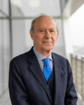 Dr Farhad Daftary, IIS Governor, in a navy three-piece suit, striped shirt and bright blue tie.