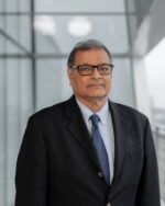 Habib Motani, IIS Governor, in black-framed glasses, a dark jacket, light-blue shirt and navy tie.