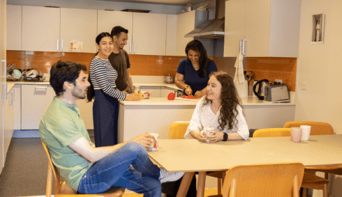 STEP students socialising and preparing food together in a shared residence kitchen.