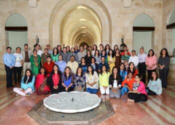 A group of intellectuals posing for a photo at the entrance of Dubai Ismaili Centre