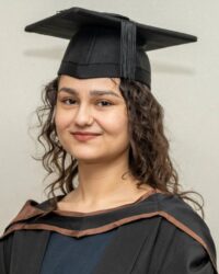 GPISH graduate Kiran Rehmat in academic cap and gown, studio portrait.