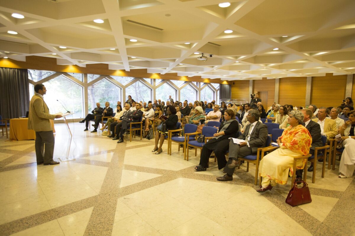 A man addressing a big group of people in a room