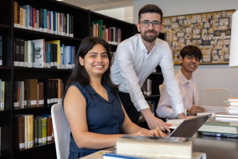 STEP students studying with books and a laptop in the Aga Khan Library.