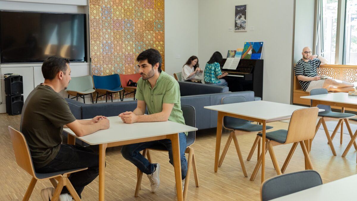 STEP students in conversation in the student lounge, with others in the background.
