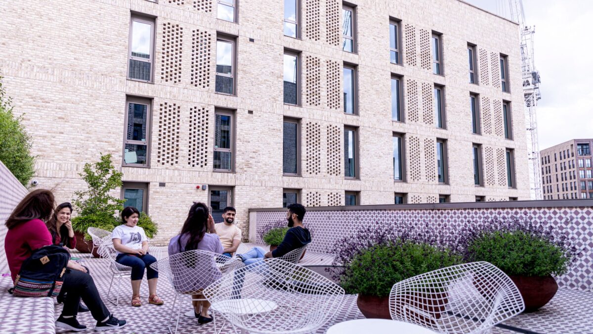 STEP students sitting and talking together on the outdoor terrace at Victoria Hall.