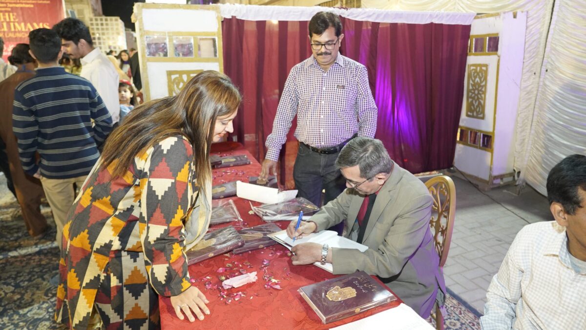 Translator Dr Rehmani signing a copy of Ismaili Imams