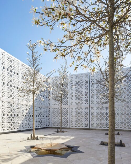 a white wall with trees in it - garden of light