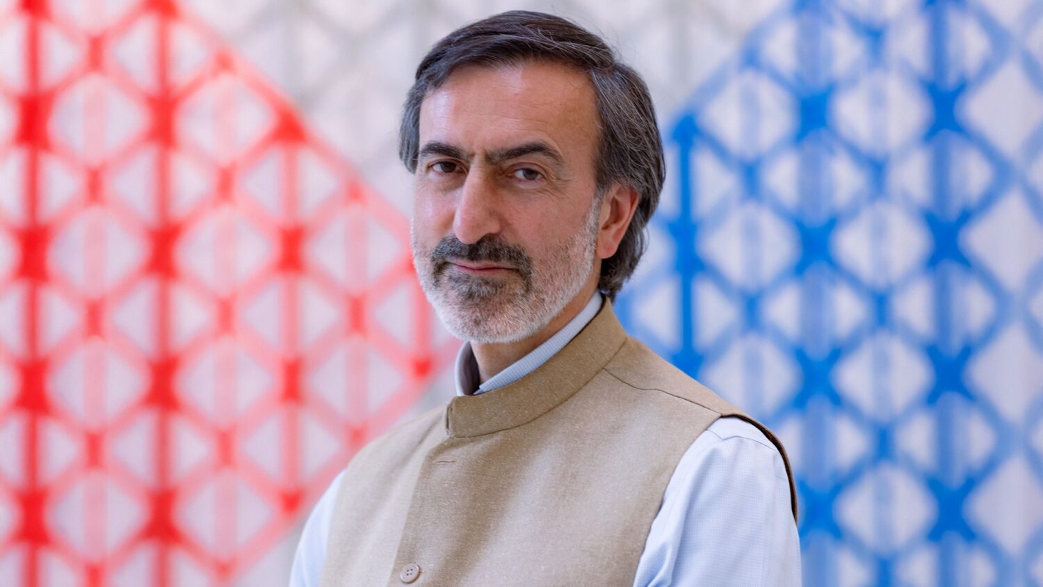 Man in traditional attire, colourful background.