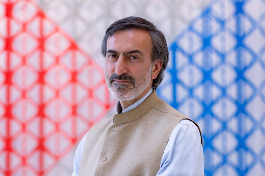 Man in traditional attire, colourful background.