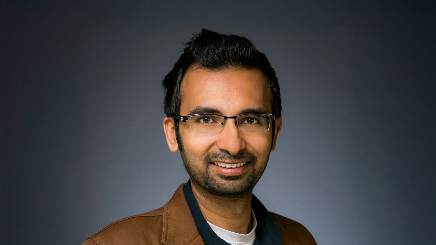 Man in brown jacket, neutral background. History teaching in europe
