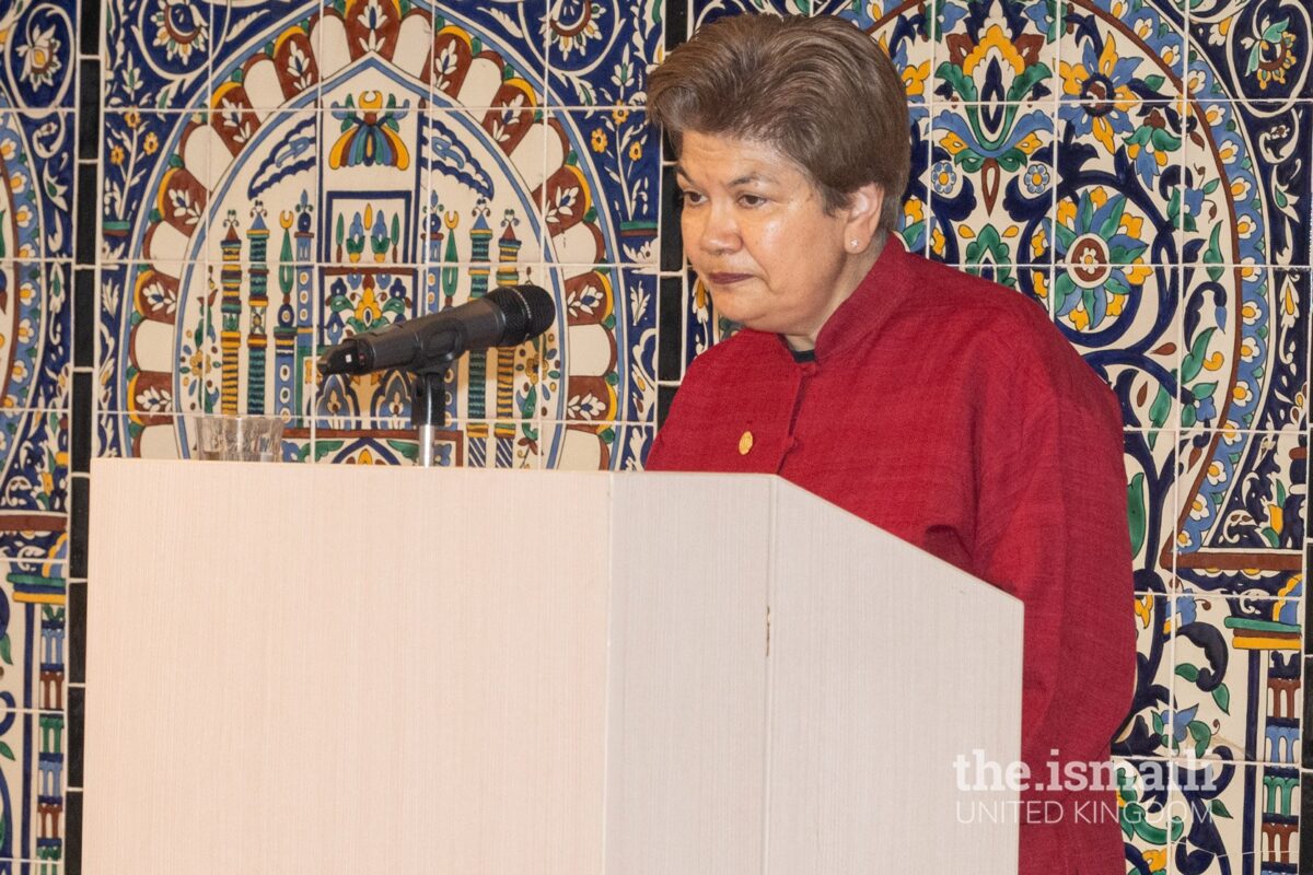 Speaker at podium with decorative background.