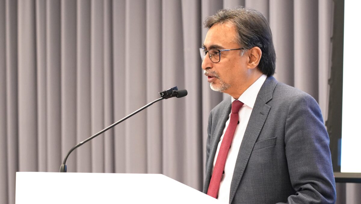 Man speaking at a conference podium.