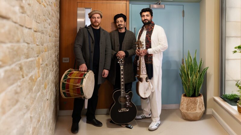Three musicians standing with instruments before their performance at the Aga Khan Music Awards Freestage 2025.