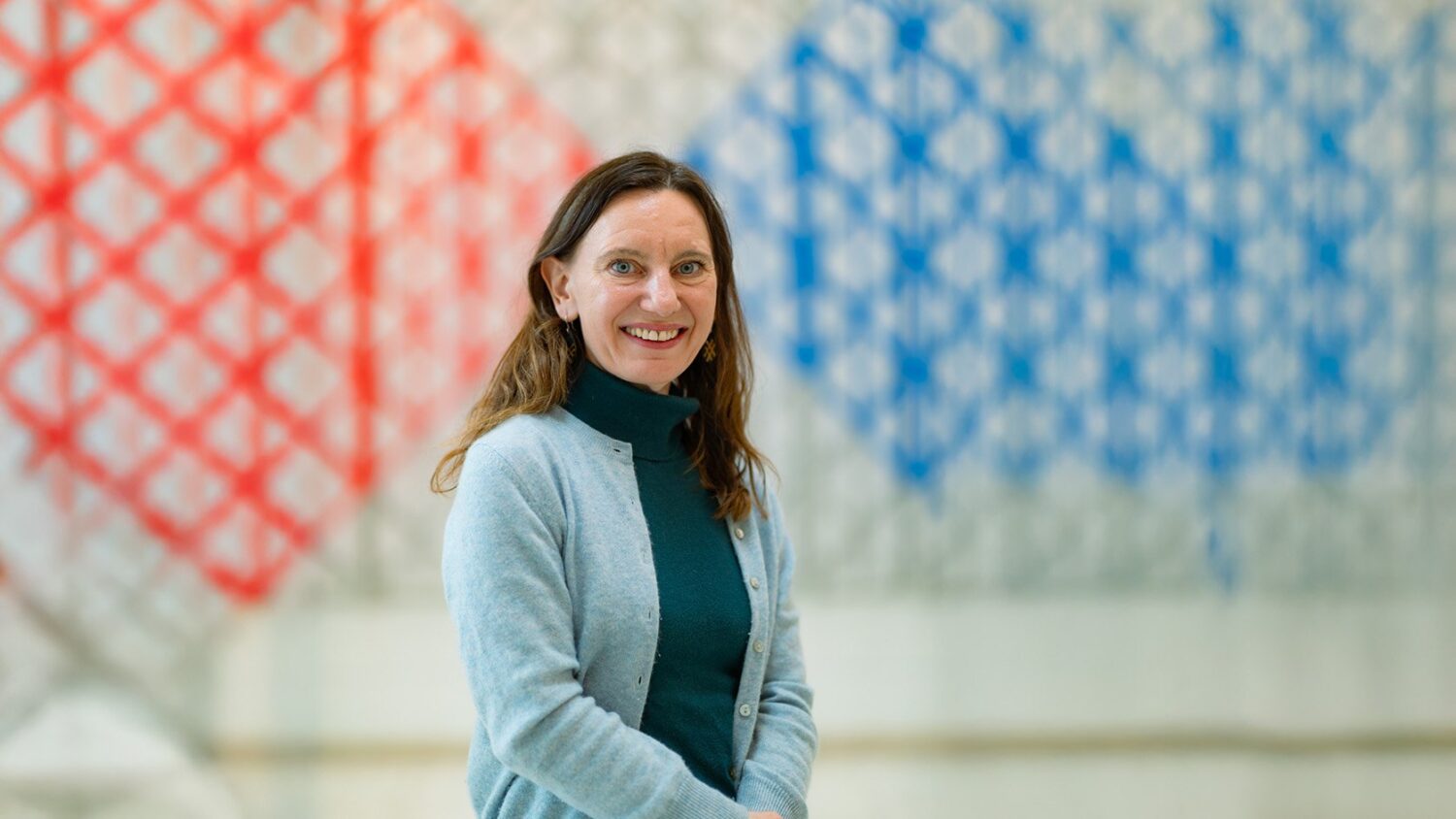 Karen Bauer at the Aga Khan Centre with geometric artwork in the background