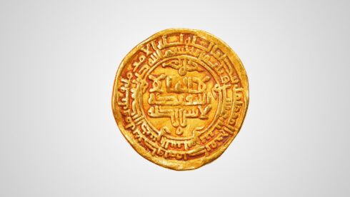 Ancient Fatimid gold coin with intricate inscriptions.