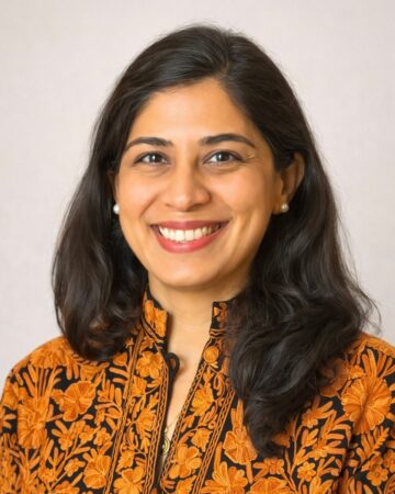 Professor Shenila Khoja-Moolji in embroidered orange attire.