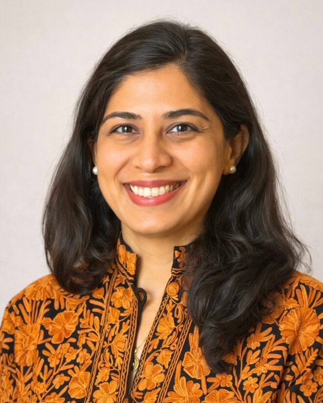 Professor Shenila Khoja-Moolji in embroidered orange attire.