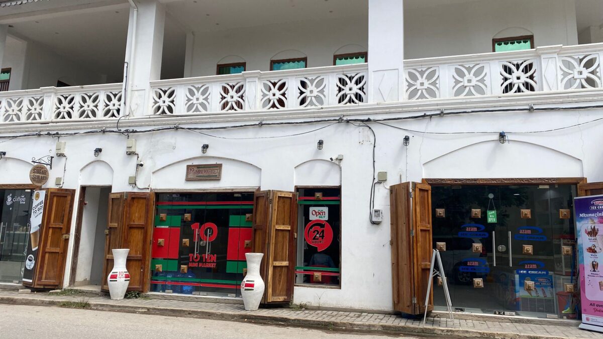 House with wooden shutters and signage.