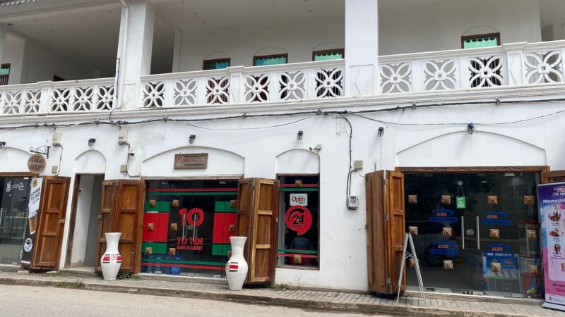 House with wooden shutters and signage.
