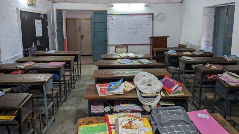 Empty classroom with wooden desks and textbooks at a girls’ school in Gujranwala, Pakistan