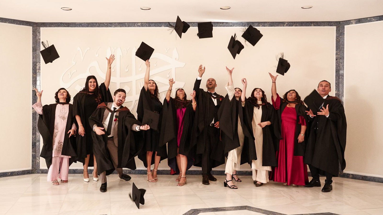 IIS Class of 2026 graduates celebrating with caps in the air