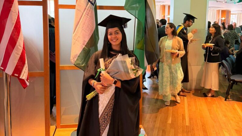 Sara Charania holding flowers at the graduation ceremony