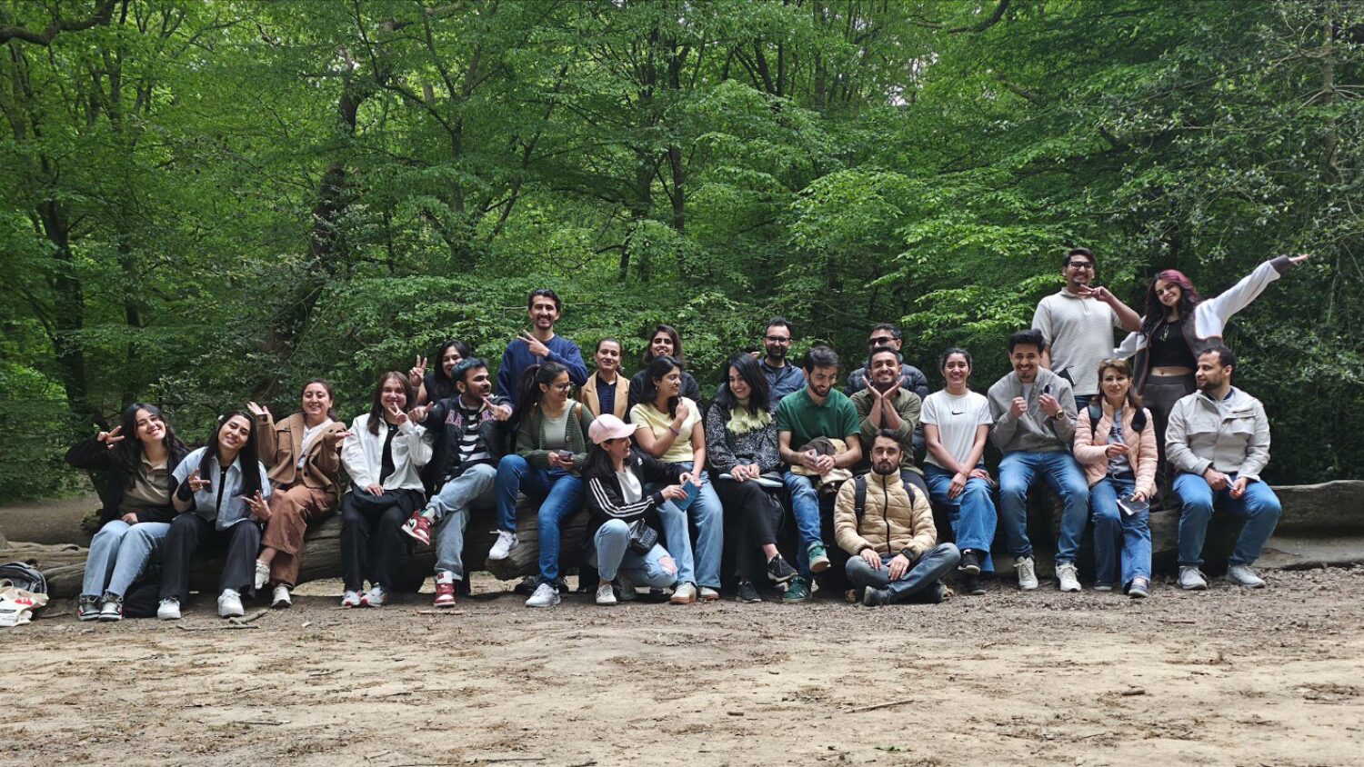 Large group of friends outdoors, smiling in nature.