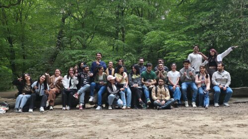 Large group of friends outdoors, smiling in nature.