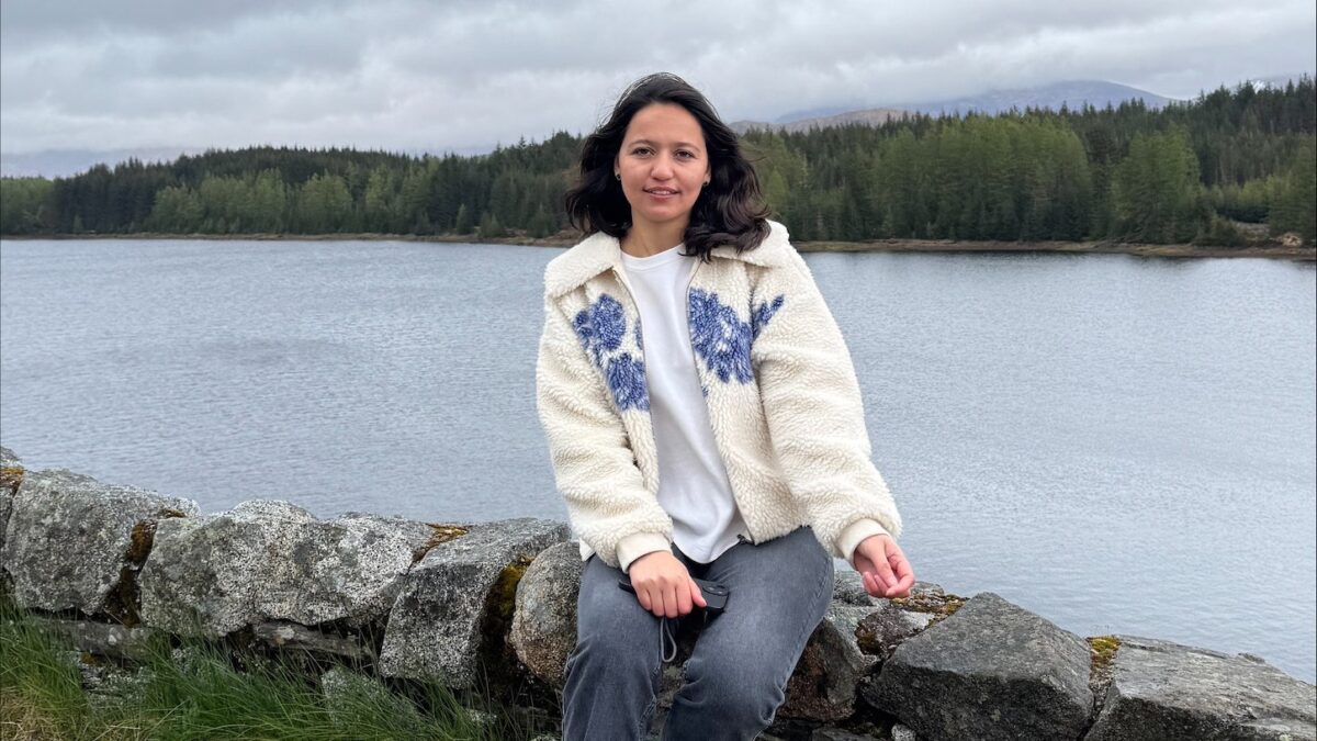 Abidah Nasreen seated by a lake during on of the STEP outdoor learning workshops.