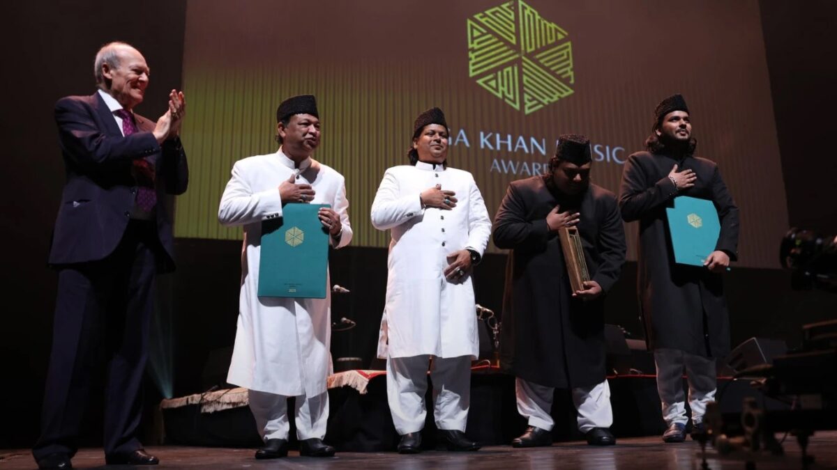 Prince Amyn Aga Khan applauds as the Warsi Brothers receive the Aga Khan Music Awards 2025 Patron's Award on stage.