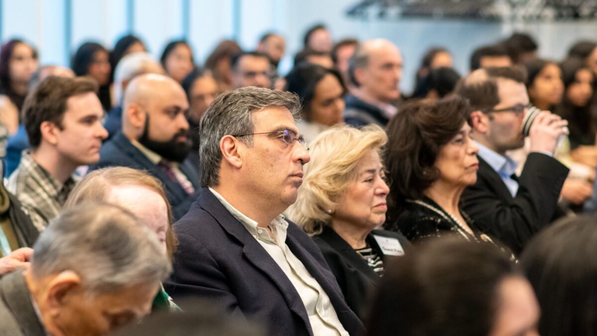 Audience members listening attentively during an evening event at the Aga Khan Centre.