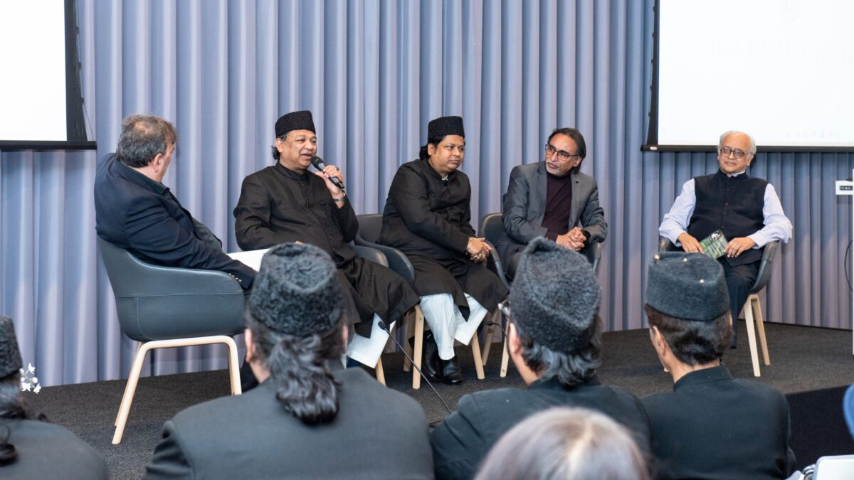 Panel discussion at the Aga Khan Centre with the Warsi Brothers, Hussain Jasani and Jay Visvadeva, one panellist speaking into a microphone.