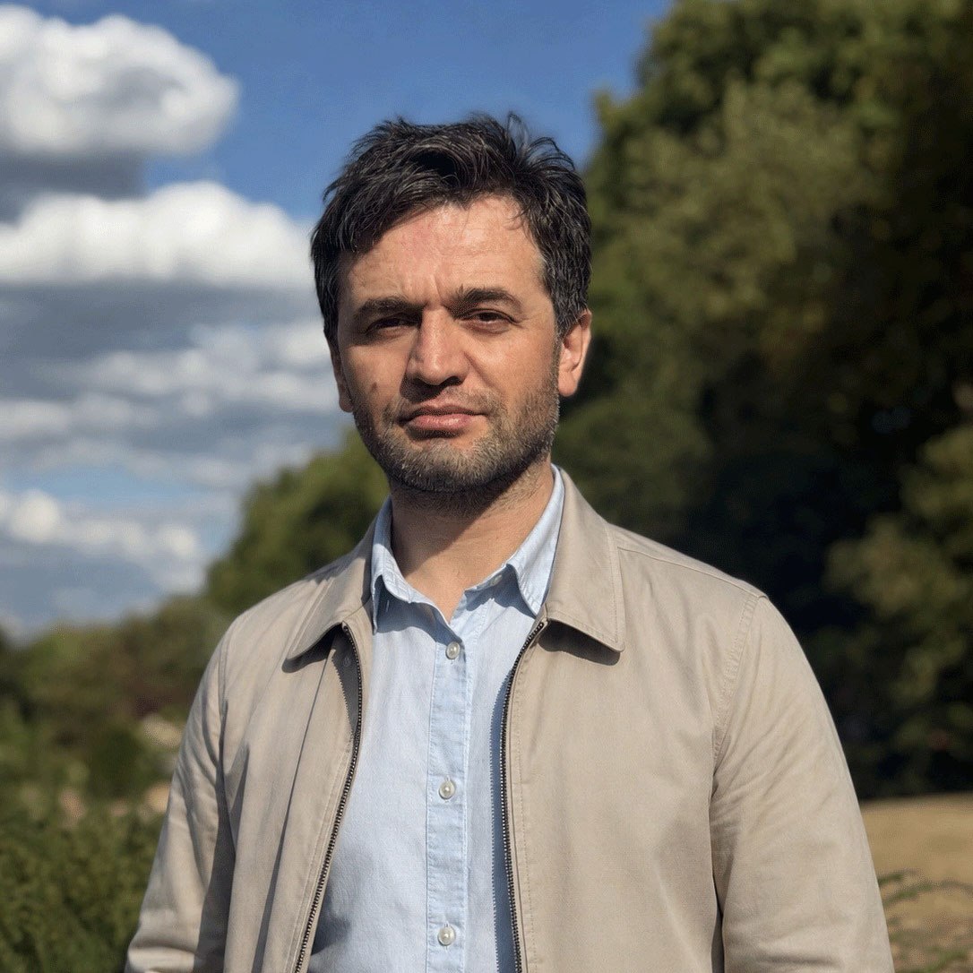 Hidoyatullo Shozodamamadov, photographed outdoors against trees and a blue sky.