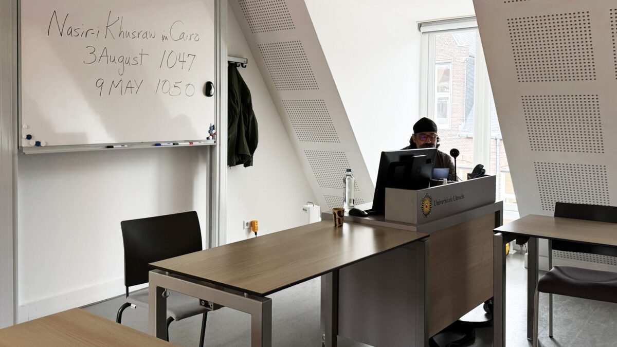 Dr Rahim Gholami at the lectern of a Utrecht University seminar room during his AIS conference paper