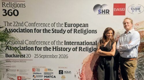 Dr Fatima Dhanani and Dr Alex Henley standing beside the Religions 360 congress banner in Bucharest.