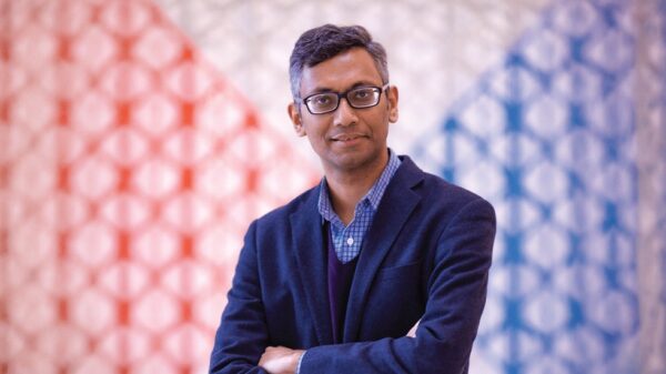 Dr Wafi Momin, Head of Ismaili Special Collections, pictured against a red and blue geometric backdrop.